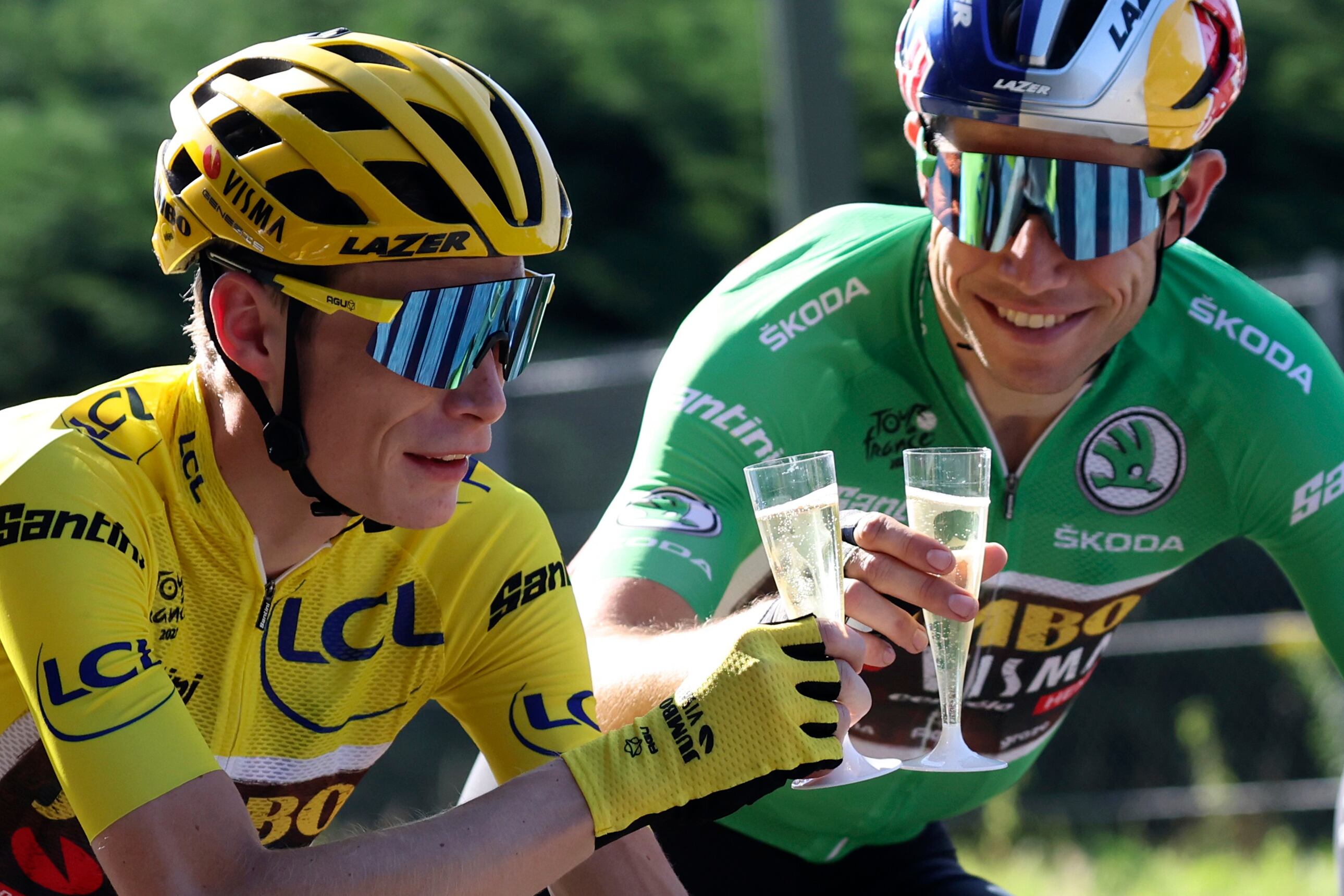 Denmark's Jonas Vingegaard, wearing the overall leader's yellow jersey, toasts champagne with teammates Belgium's Wout Van Aert, wearing the best sprinter's green jersey during the twenty-first stage of the Tour de France cycling race over 116 kilometers (72 miles) with start in Paris la Defense Arena and finish on the Champs Elysees in Paris, France, Sunday, July 24, 2022. (Thomas Samson/Pool Photo via AP)