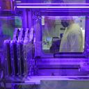 Steven Grimmett, a microbiologist on the COVID-19 team at the Washington State Department of Health's Public Health Laboratory, is seen through a window of a machine that identifies positive and negative COVID-19 cases, Dec. 7, 2021, in Shoreline, Wash. Scientists are warning that omicron’s lightning-fast spread across the globe practically ensures it won’t be the last worrisome coronavirus variant. And there’s no guarantee the next ones will cause milder illness or that vaccines will work against them. (AP Photo/Ted S. Warren)