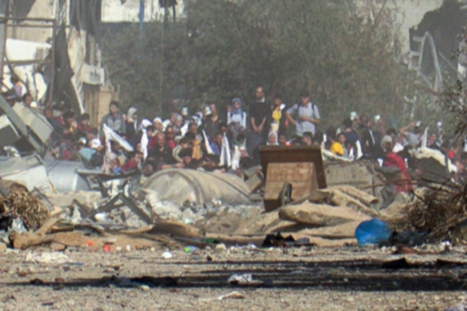 Una captura de un vídeo de AFPTV muestra a palestinos levantando banderas blancas mientras huyen a pie de la ciudad de Gaza en medio de las batallas entre Israel y el grupo terrorista Hamas