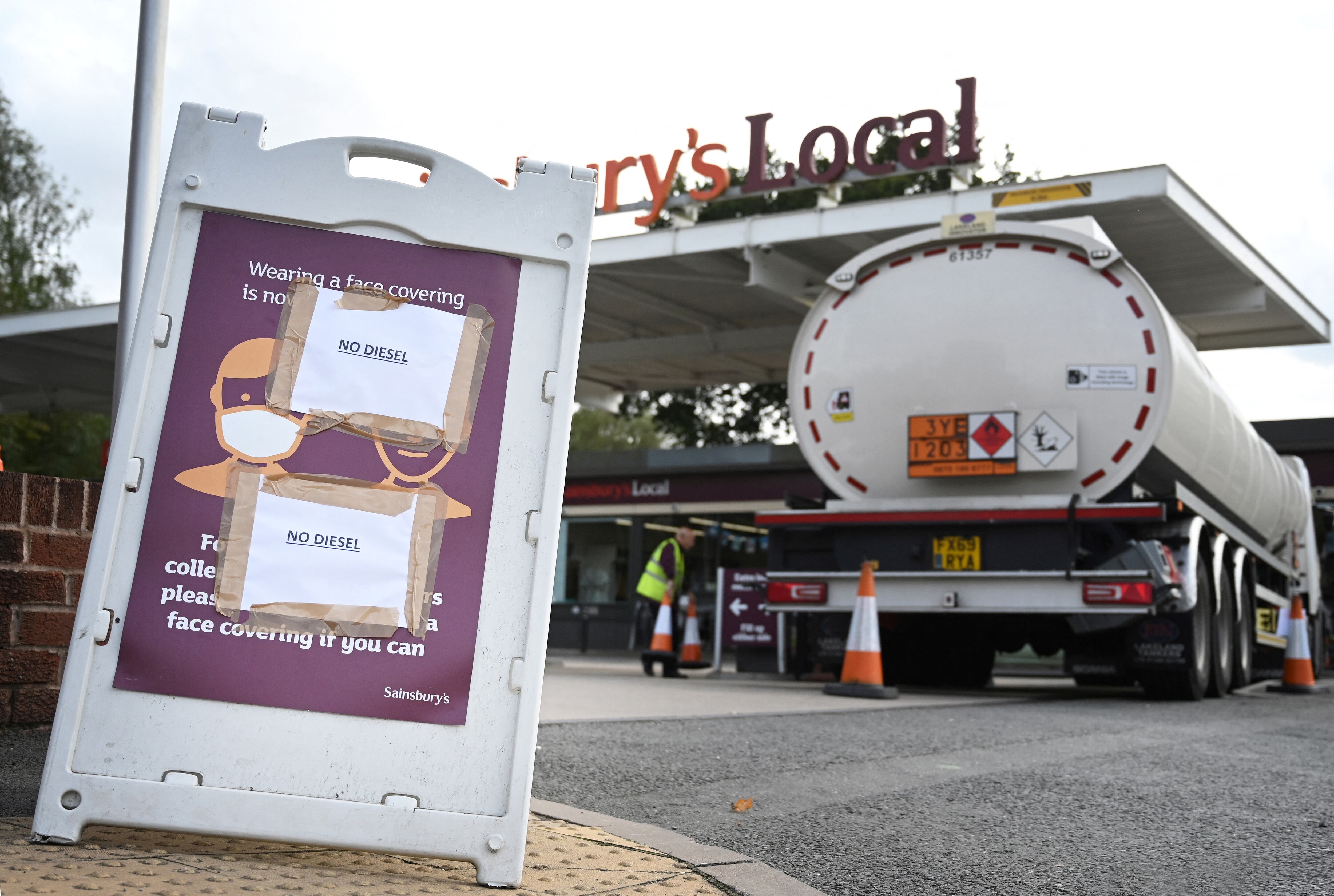 An aerial view shows motorists queueing at a petrol station in Coventry, central England on September 28, 2021. - The UK government today faced calls for nurses, police, teachers and other key workers to be given priority at petrol pumps, as the army was put on standby to ease a fuel supply crisis. (Photo by Paul ELLIS / AFP)