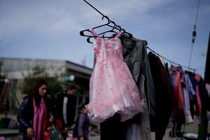 Prendas de segunda mano se exhiben en un tendedero improvisado en un mercado donde la gente puede comprar o intercambiar productos, en las afueras de Buenos Aires, Argentina, el miércoles 10 de agosto de 2022. Foto AP/Natacha Pisarenko