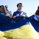 Las mujeres sostienen una bandera ucraniana cerca de las instituciones europeas durante una manifestación llamada "Las mujeres están con Ucrania" contra la operación militar de Rusia en Ucrania como parte del Día Internacional de la Mujer en Bruselas, el 8 de marzo de 2022.
Kenzo TRIBOUILLARD / AFP