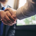 Dos hombres de negocios dándose la mano durante una reunión para firmar un acuerdo y convertirse en un socio comercial, empresas, empresas, confianza, éxito en el trato, contrato entre sus empresas.