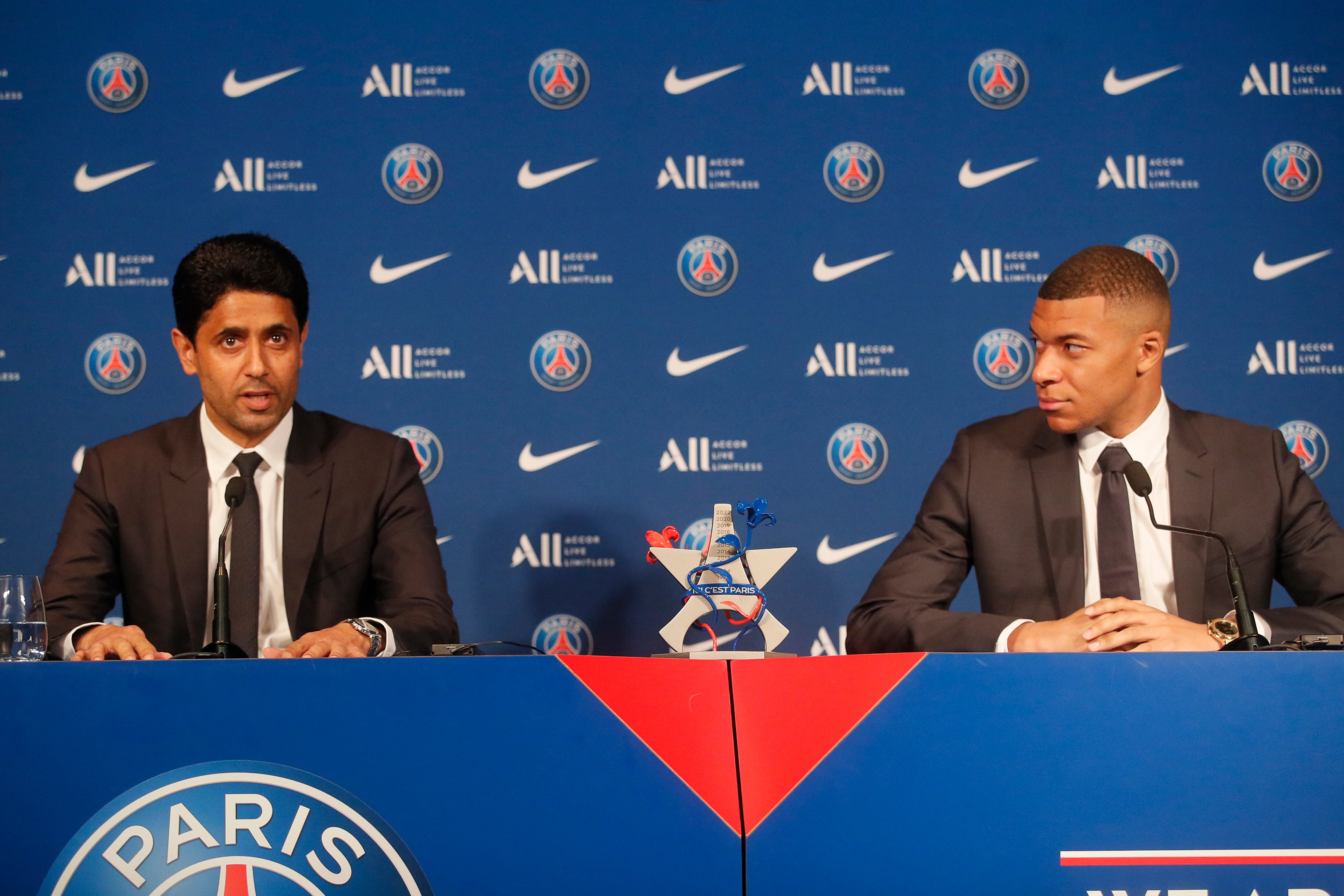 PSG striker Kylian Mbappe, right, and PSG president Nasser Al-Al-Khelaifi attend a press conference Monday, May 23, 2022 at the Paris des Princes stadium in Paris. Kylian Mbappé's decision to reject Real Madrid and commit to Paris Saint-Germain for three more seasons marks the start of a large rebuilding project at the French league champion. (AP Photo/Michel Spingler)