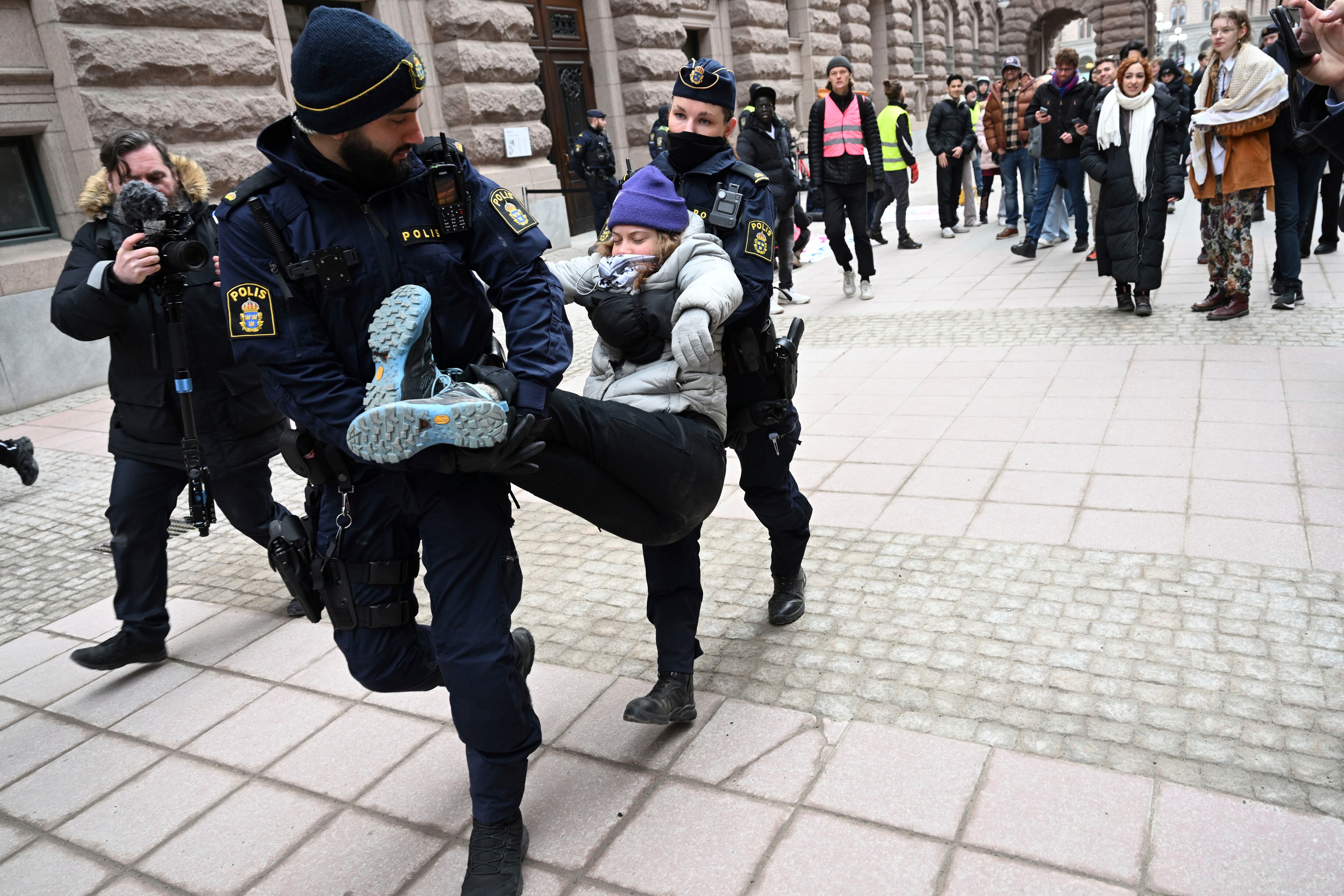 La activista climática Greta Thunberg es llevada por la policía después de manifestarse con un grupo de activistas frente al edificio del Parlamento sueco, en Estocolmo, el miércoles 13 de marzo de 2024.