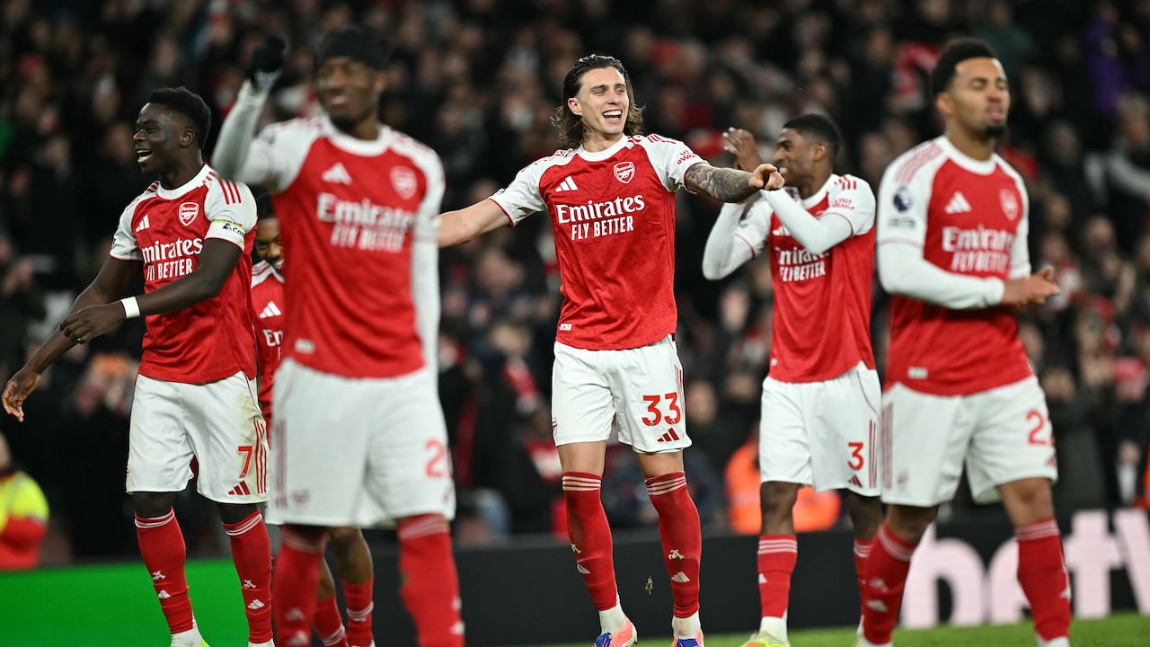 El centrocampista inglés del Arsenal, Bukayo Saka (izq.), y el defensa italiano del Arsenal, Riccardo Calafiorim (centro), celebran tras el partido de la Premier League entre el Arsenal y el Tottenham Hotspur en el Emirates Stadium de Londres el 23 de noviembre de 2025. El Arsenal ganó 4-1. (Foto de Ben STANSALL / AFP)