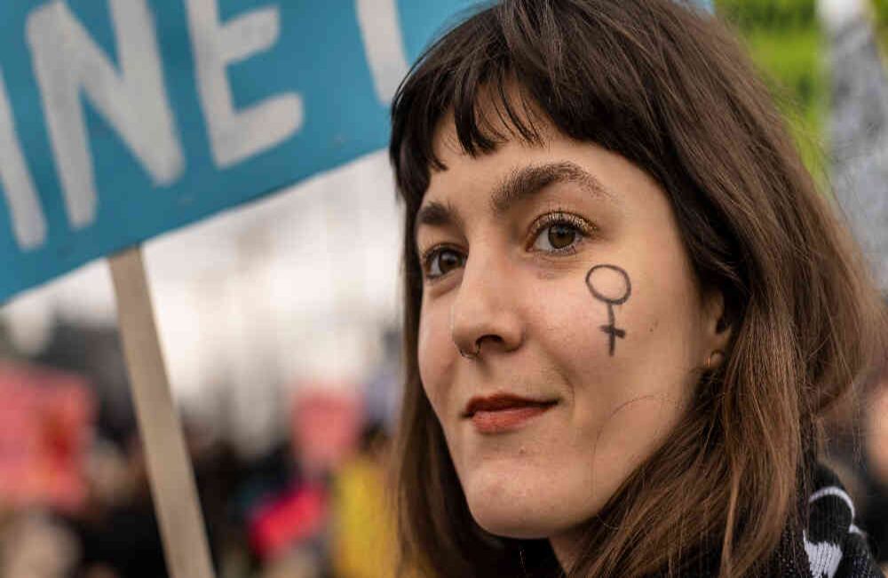Una manifestante, con el símbolo femenino pintado en su rostro, asiste a una marcha feminista por  la defensa de los derechos de las mujeres y la emergencia climática  mundial en Varsovia, Polonia, en ocasión del Día Internacional de la Mujer, el 8 de marzo de 2020. (Foto: Wojtek Radwanski / AFP)