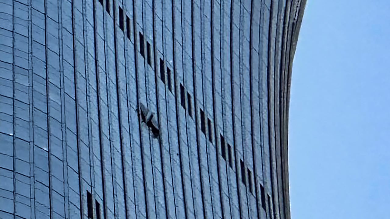 Se observa un agujero (a la derecha) en un lateral de la Torre CITIC en Pekín, el 26 de junio de 2026, después de que un testigo presencial informara de la presencia de restos de un avión en la base del edificio más alto de la ciudad.