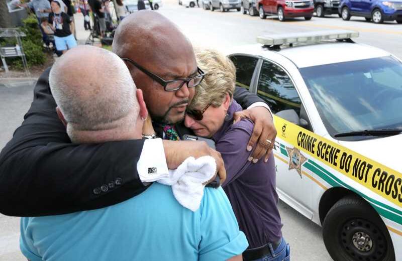 Kelvin Corbaris, un clérigo de Orlanto, consuela a dos activistas de derechos homosexuales en las cercanías de la escena del crimen. Foto: AP