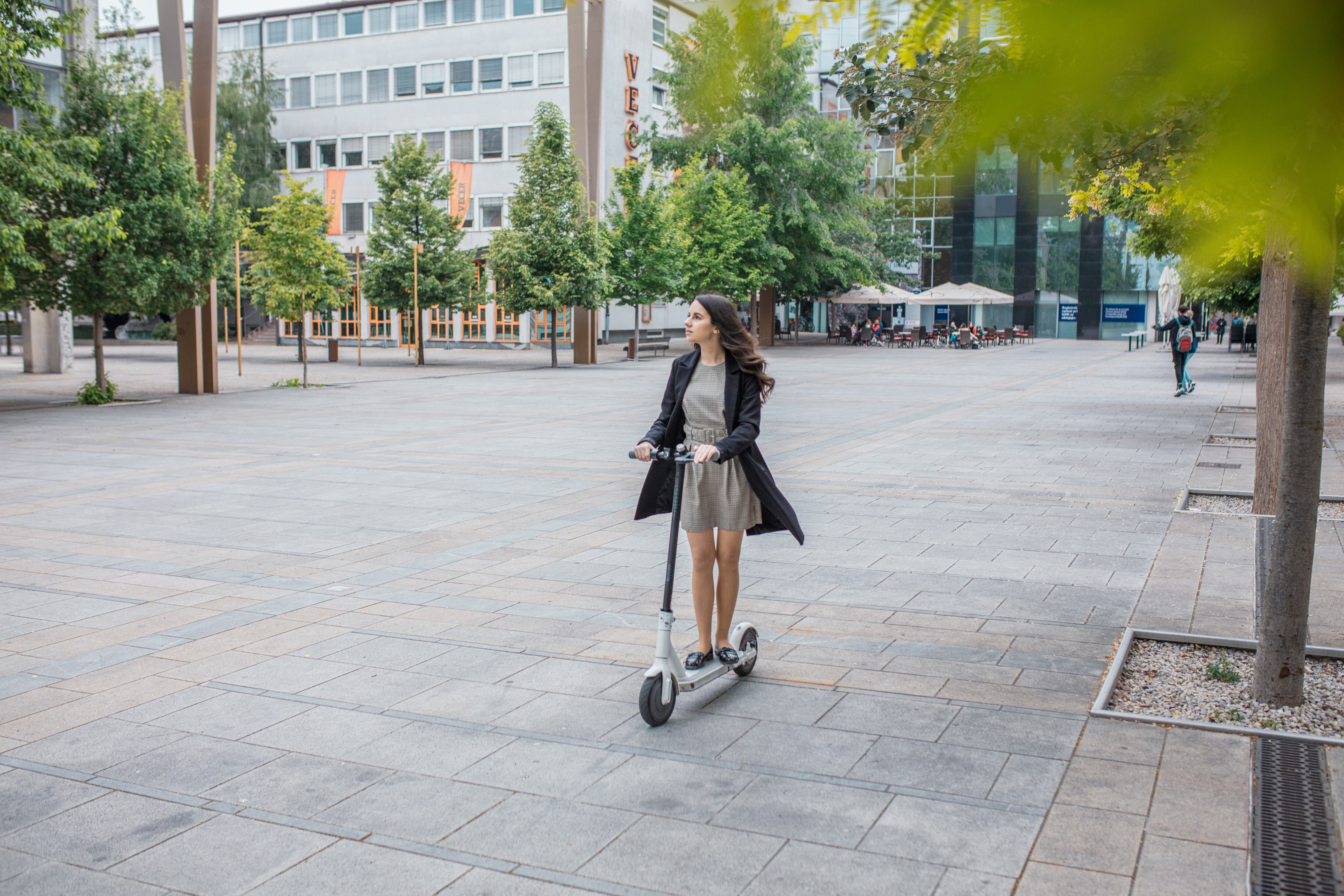 Mujer joven montando en patineta eléctrica
