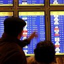 Dos personas consultan en las pantallas los primeros vuelos de la mañana en el aeropuerto de Madrid-Barajas, que aún sufren retrasos y pocas cancelaciones, aunque casi la totalidad de las aerolíneas factura regularmente.