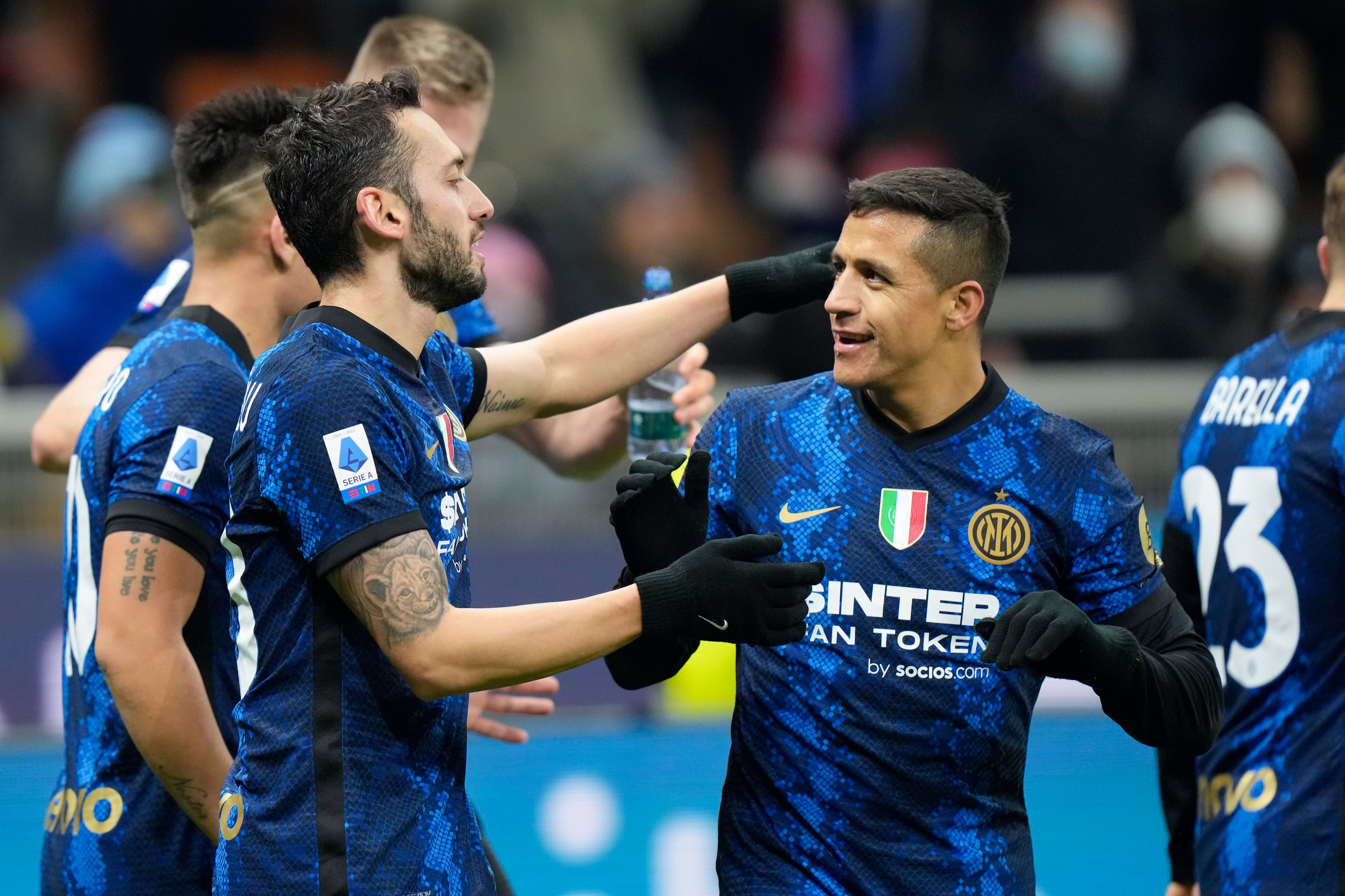 Inter Milan's Alexis Sanchez, right, congratulates teammate Hakan Calhanoglu who scored his side's third goal during a Serie A soccer match between Inter Milan and Cagliari at the San Siro stadium in Milan, Italy, Sunday, Dec.12, 2021. (AP Photo/Luca Bruno)