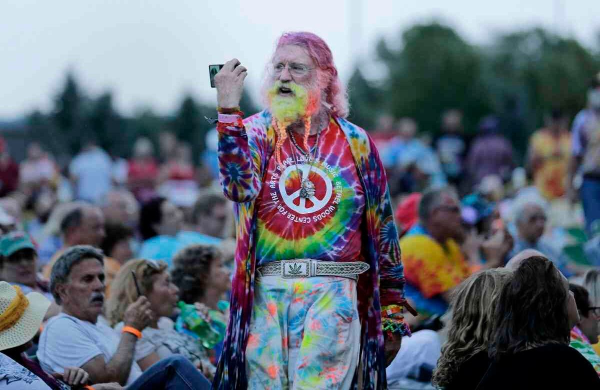 Un hombre camina entre la multitud durante un concierto de Arlo Guthrie que conmemora el 50 aniversario de Woodstock en Bethel, Nueva York, el jueves 15 de agosto de 2019. Se espera que los fanáticos de Woodstock regresen al lugar para conmemorar el 50 aniversario del festival que marcó a toda una generación. Bethel Woods Center for the Arts está organizando una serie de eventos de jueves a domingo en el bucólico sitio de los conciertos de 1969, 130 kilómetros al noroeste de la ciudad de Nueva York. (Foto AP / Seth Wenig)