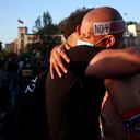 Dos hombres, uno con un letreo en la cabeza que dice "No más abusos", se abrazan el día en que los chilenos votaron en un referéndum para decidir si el país debería reemplazar su constitución de 40. Foto: AP / Luis Hidalgo.