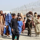 Afghan people walk inside a fenced corridor as they enter Pakistan at the Pakistan-Afghanistan border crossing point in Chaman on August 25, 2021 following the Taliban's stunning military takeover of Afghanistan. (Photo by - / AFP)