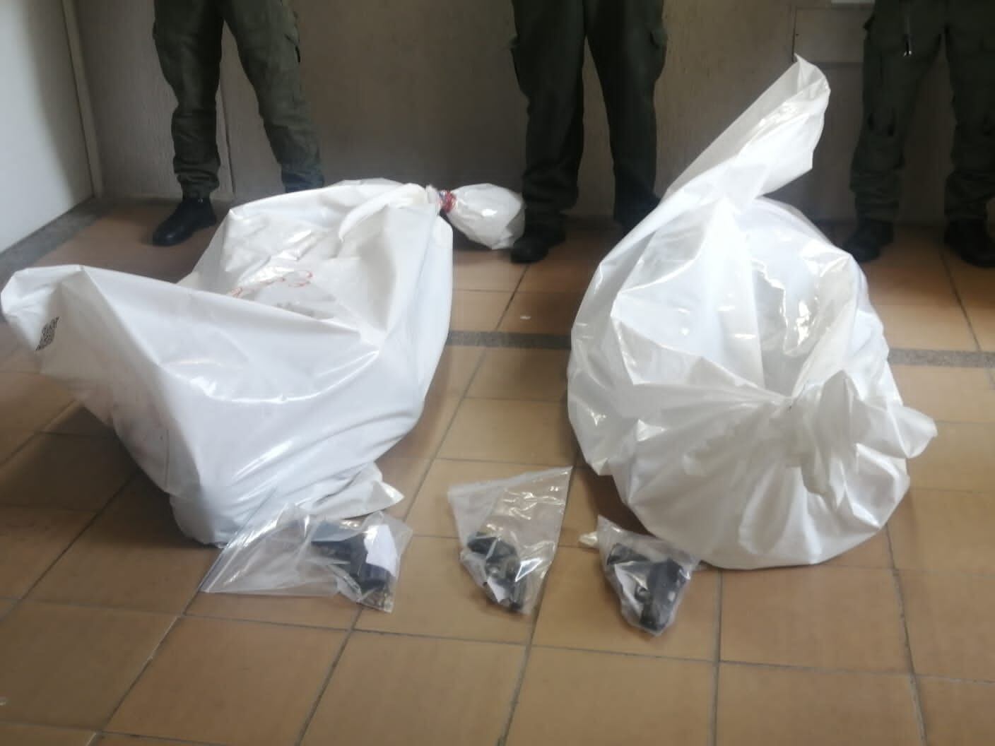 Los cuerpos de alias Nico y alias Jordan, junto a las armas incautadas en el operativo.