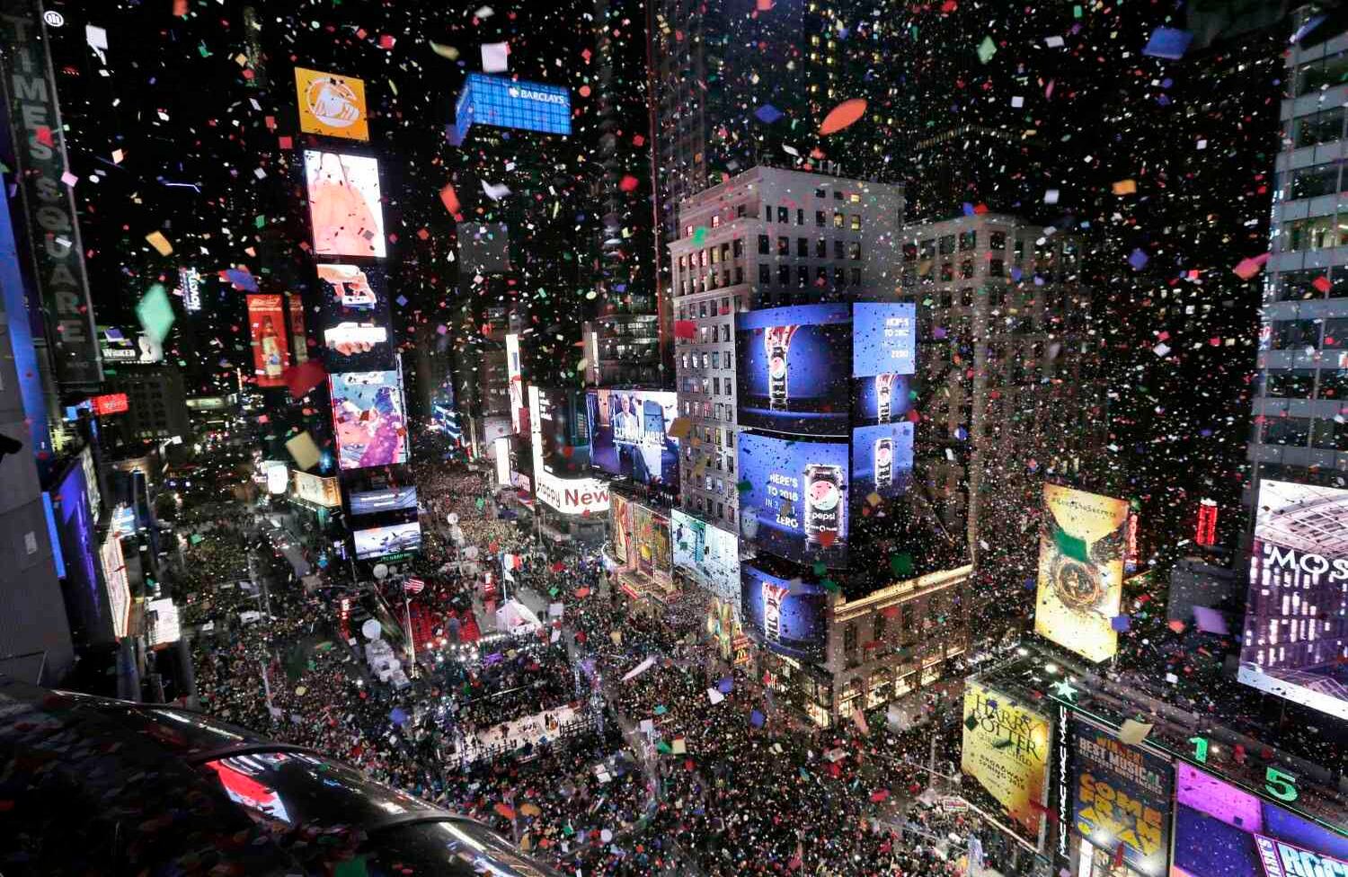 Confeti cae sobre la multitud cuando el reloj marca la medianoche durante la celebración de Año Nuevo en Times Square, visto desde el Marriott Marquis en Nueva York, el lunes, enero. 1, 2018. (AP Photo / Seth Wenig).