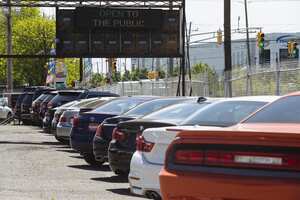An "Open To The Public" sign is displayed over a used car dealership in Jersey City, New Jersey, U.S, on Wednesday, May 20, 2020. Governor Phil Murphy has lifted restrictions on in-person auto sales, provided the businesses follow social distancing guidelines, NBC reported. Photographer: Angus Mordant/Bloomberg via Getty Images