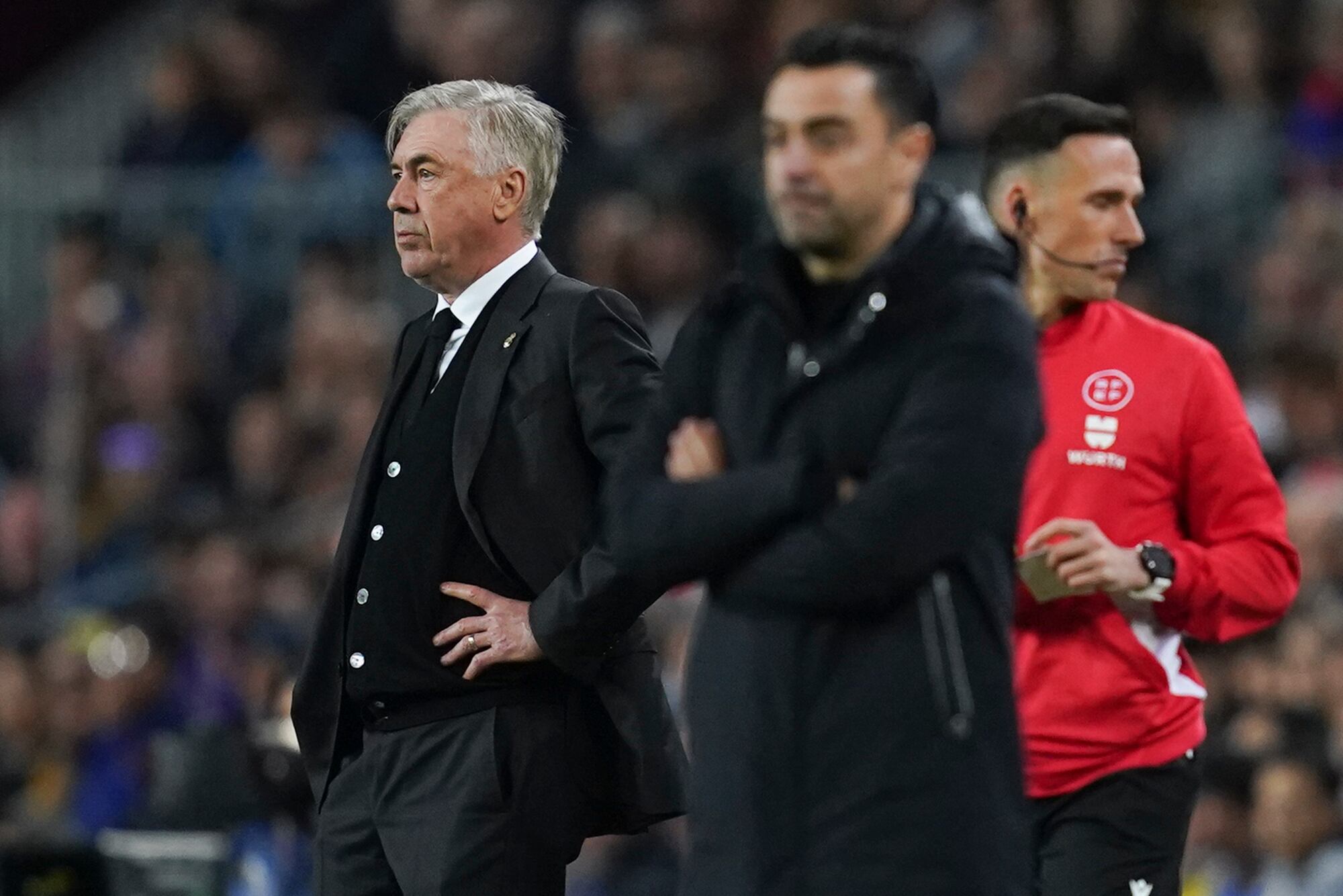Real Madrid's head coach Carlo Ancelotti, left, stands near Barcelona's head coach Xavi Hernandez during the Spanish La Liga soccer match between Barcelona and Real Madrid at Camp Nou stadium in Barcelona, Spain, Sunday, March 19, 2023. (AP Photo/Joan Mateu)