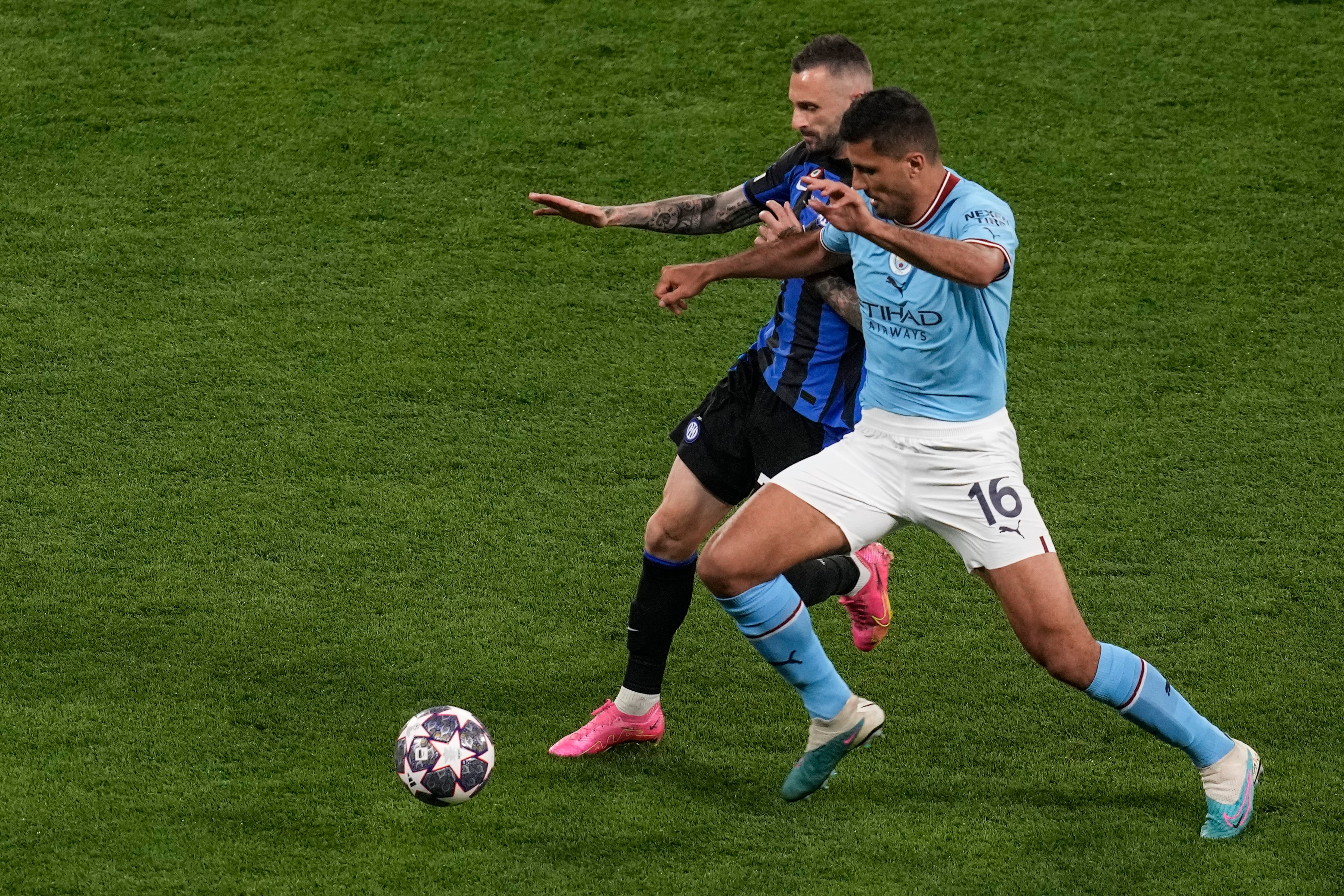 Rodrigo, del Manchester City, a la derecha, y Marcelo Brozovic, del Inter de Milán, compiten por el balón durante el partido final de la Liga de Campeones entre el Manchester City y el Inter de Milán en el Estadio Olímpico Ataturk en Estambul, Turquía, el sábado 10 de junio de 2023. (Foto AP/Thanassis Stavrakis)