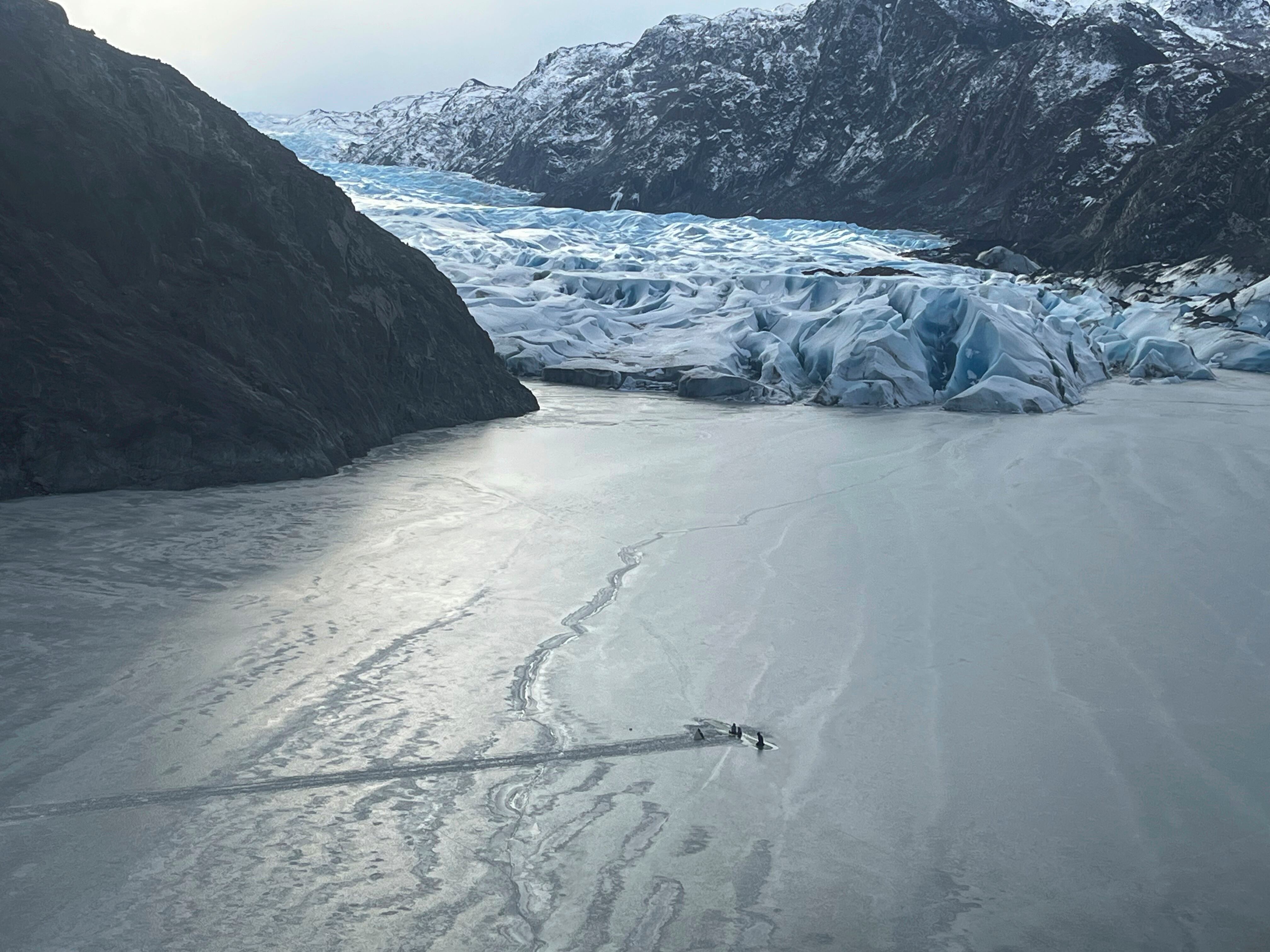 This photo provided by the Alaska National Guard shows an airplane partially submerged into the ice of Tustumena Lake at the toe of a glacier on Monday, March 24, 2025, near Soldotna, Alaska. (Alaska National Guard via AP)