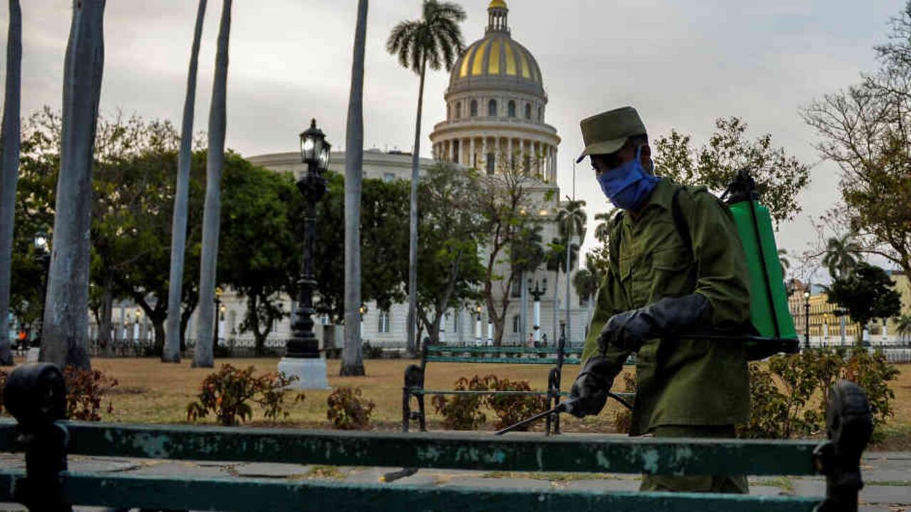 Un miembro de las fuerzas armadas cubanas desinfecta una plaza durante la pandemia del nuevo coronavirus.