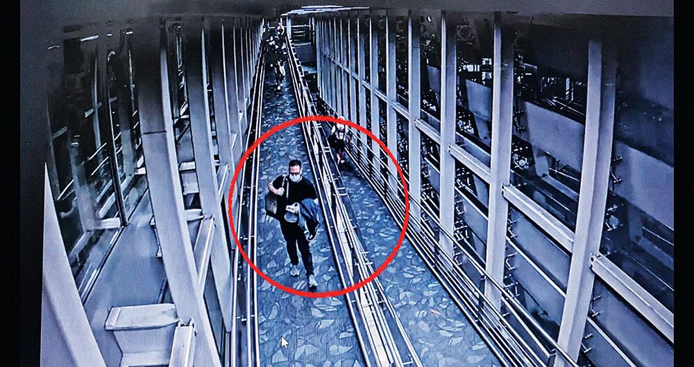 DOMINGO 22 DE ENERO, 10:00 P. M. Se conocen las últimas imágenes de John Poulos antes de dejar el país y viajar rumbo a Panamá. Camina por las rampas que llevan a las zonas de abordaje. 