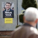 Un hombre camina junto a carteles de campaña de los candidatos presidenciales franceses, el actual presidente Emmanuel Macron (L) y la candidata presidencial del partido de extrema derecha francés Rassemblement National (RN) Marine Le Pen en Denain, el 11 de abril de 2022. Emmanuel Macron obtuvo el 27,85 por ciento de los votos. en la primera ronda de las elecciones presidenciales de Francia, mientras que la veterana de extrema derecha Marine Le Pen obtuvo un 23,15 por ciento, según los resultados finales del Ministerio del Interior el lunes.(Foto por Ludovic MARIN / AFP)