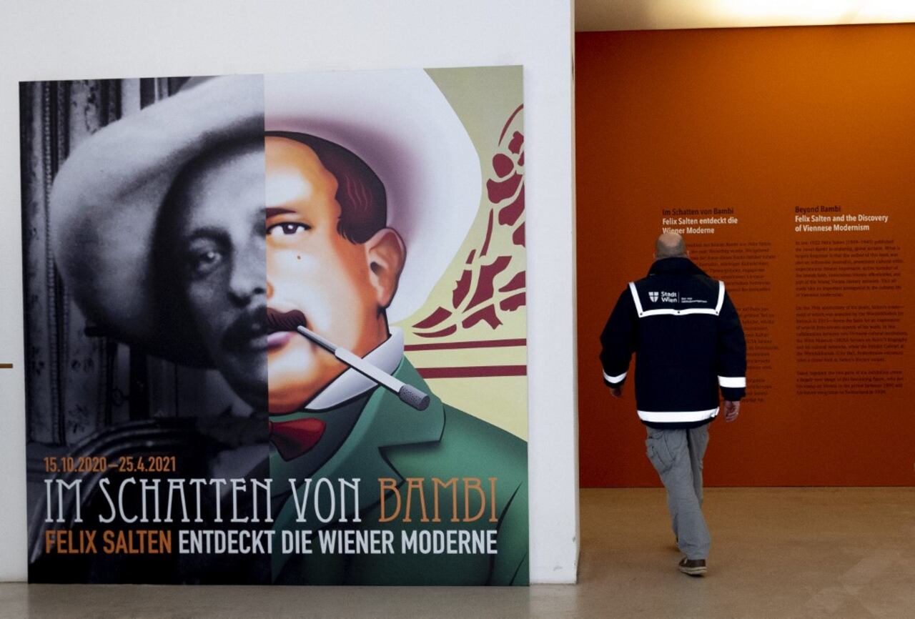 Un hombre pasa junto a un póster de Felix Salten (izquierda) al entrar en la exposición "Más allá de Bambi - Felix Salten y el descubrimiento del modernismo vienés" en el Museo de Viena el 23 de marzo de 2021. Foto de Joe Klamar / AFP