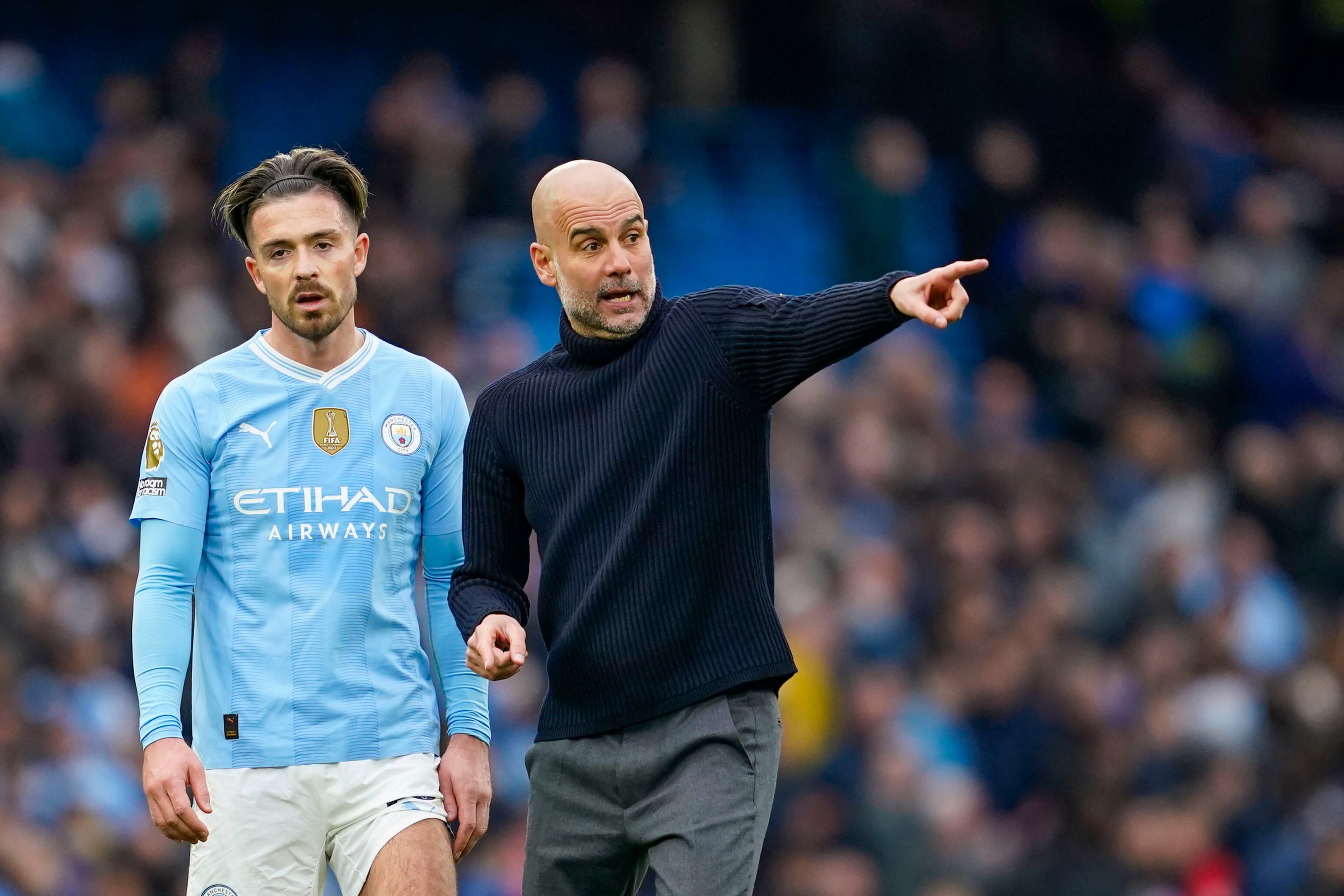 Manchester City's head coach Pep Guardiola, right, speaks with Manchester City's Jack Grealish at the end of the English Premier League soccer match between Manchester City and Arsenal at the Etihad stadium in Manchester, England, Sunday, March 31, 2024. (AP Photo/Dave Thompson)