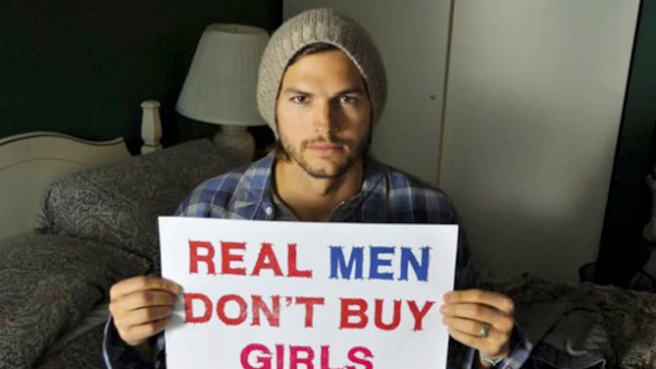 Ashton Kutcher sosteniendo el cartel de la campaña.