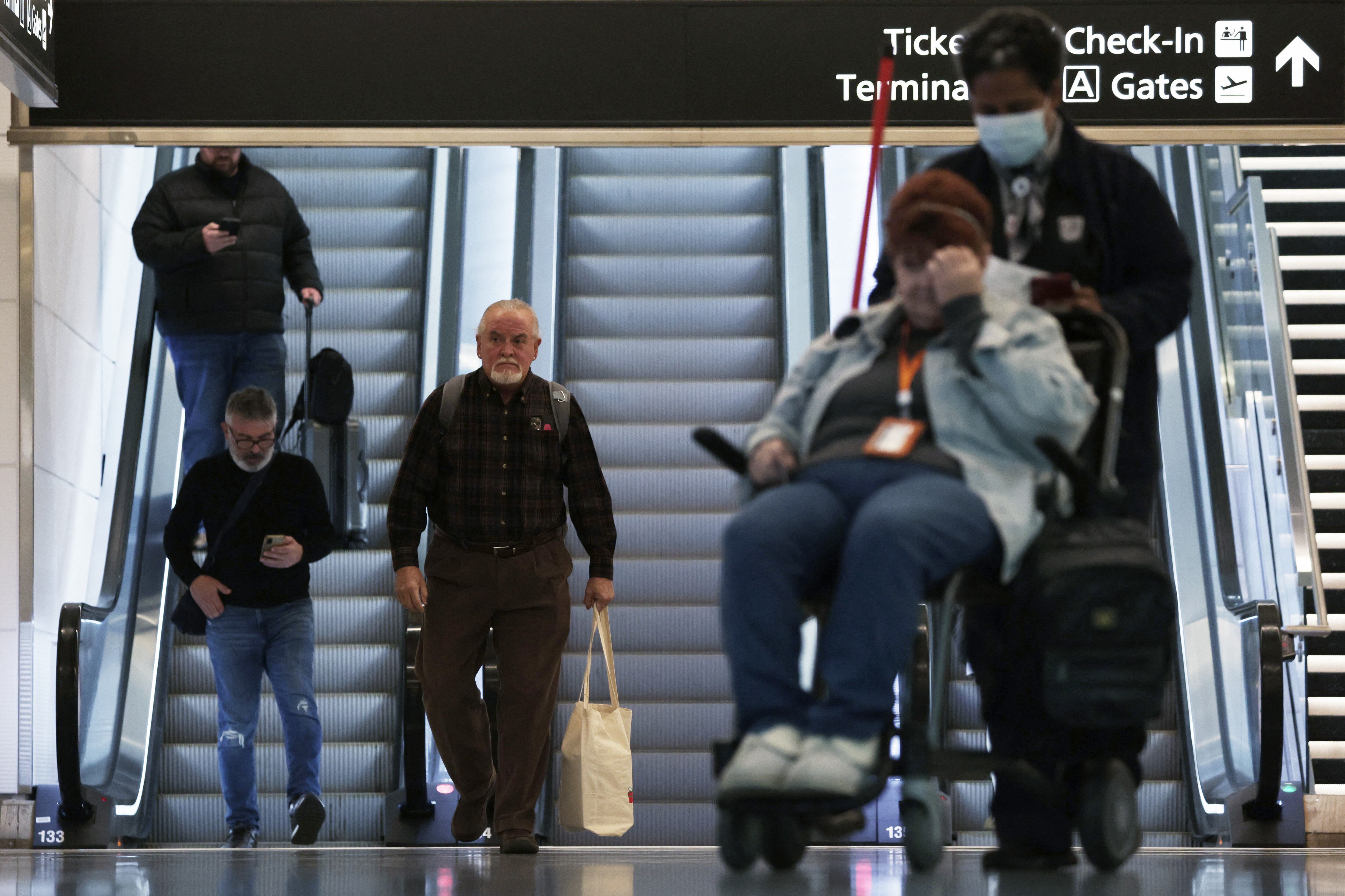 Los viajeros caminan por la terminal del Aeropuerto Nacional Ronald Reagan de Washington el 11 de enero de 2023 en Arlington, Virginia. La FAA dijo que está reanudando gradualmente los vuelos en todo el país después de una interrupción del Sistema de Aviso para Misión Aérea, un sistema informático que ayuda a guiar el tráfico aéreo. Alex Wong/Getty Images/AFP (Foto de ALEX WONG/GETTY IMAGES NORTH AMERICA/Getty Images vía AFP)