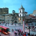 En las intersecciones de Avendia Jiménez y Carrera Septima, los autobuses rojos de Transmilenio llegan a la estación Museo del Oro frente a la Iglesia de San Francisco del siglo XVI, la iglesia restaurada más antigua de Bogotá.