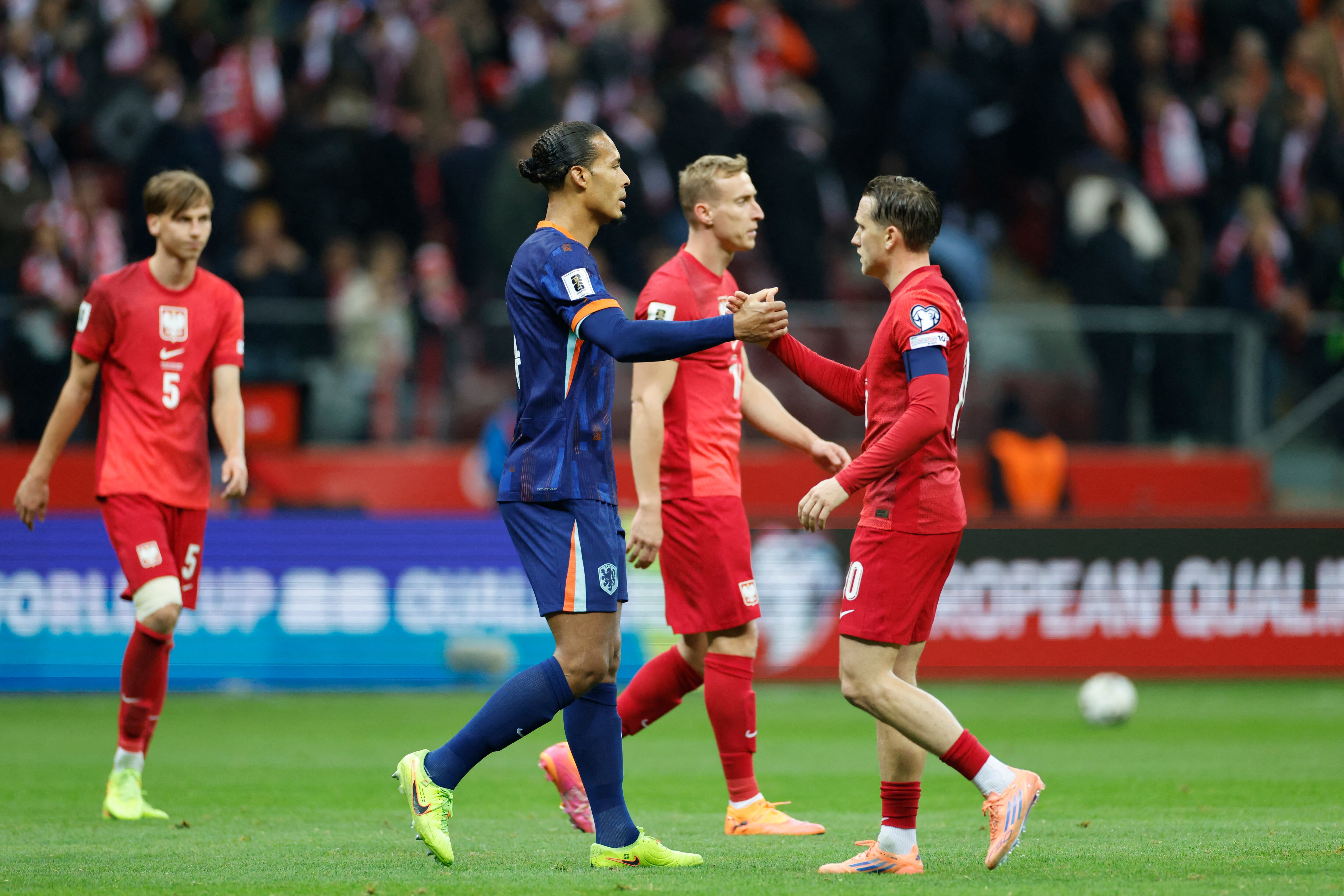 Jugadores de Polonia y los Países Bajos se dan la mano tras la finalización del partido de la primera jornada (día 9) del Grupo G de la fase de clasificación europea para la Copa Mundial de la FIFA 2026 entre Polonia y los Países Bajos, disputado el 14 de noviembre de 2025 en Varsovia, Polonia. (Foto de Wojtek RADWANSKI / AFP)