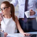 Empresario abrazando a su linda secretaria en el trabajo, ella mirando su mano