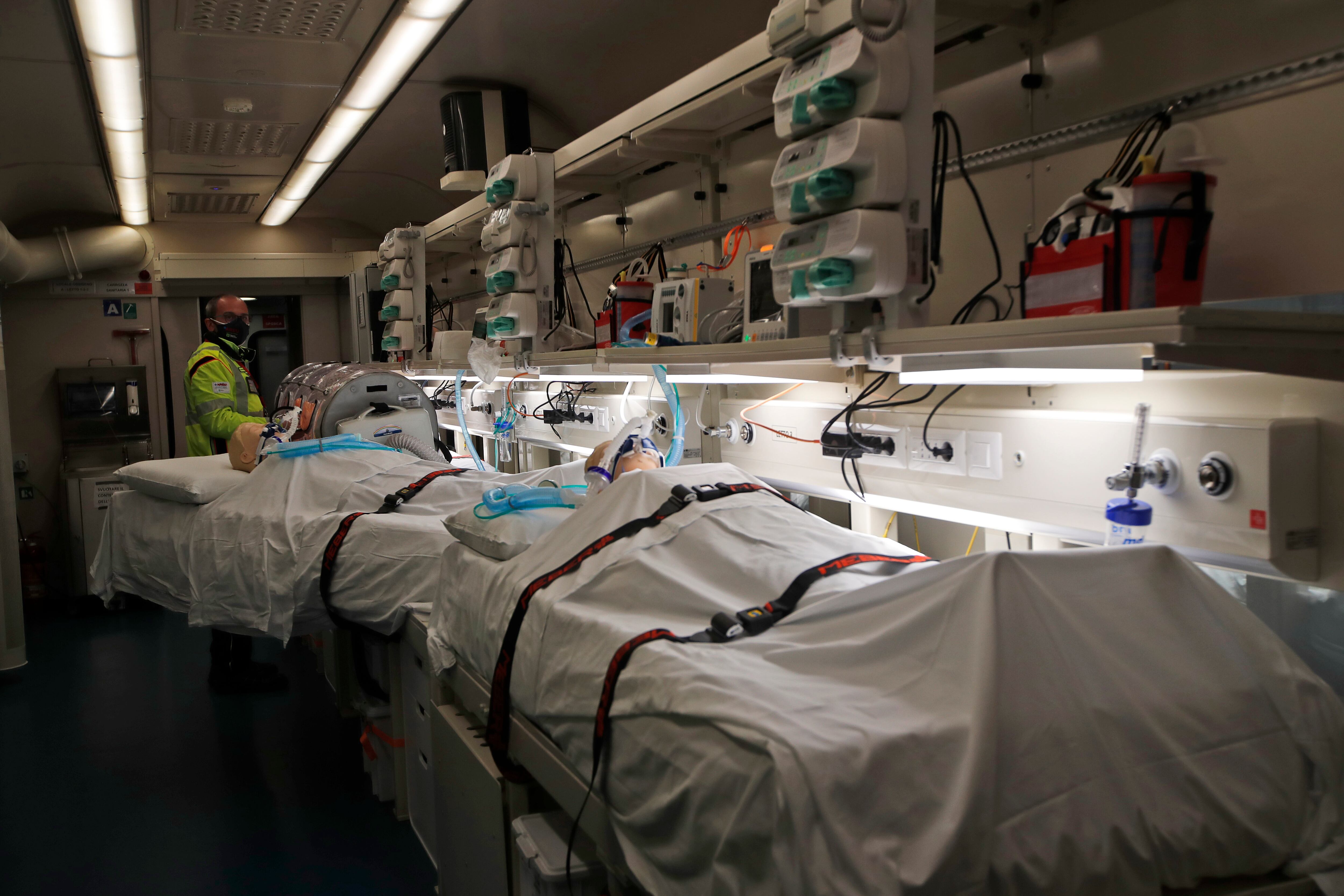 El personal de protección civil espera junto a maniquíes en camas de hospital dentro de un tren adaptado para curar pacientes, inaugurado en la estación central de Roma Termini, el lunes 8 de marzo de 2021. El tren de la salud permite trasladar y tratar a los pacientes en ocho vagones equipados con equipos específicos, entre ellos lugares de cuidados intensivos. (Foto AP / Alessandra Tarantino).