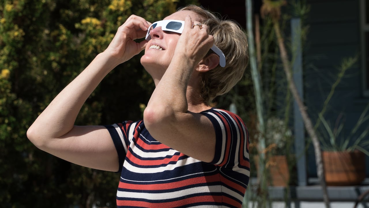 Middle aged woman with special glasses watching the eclipse.