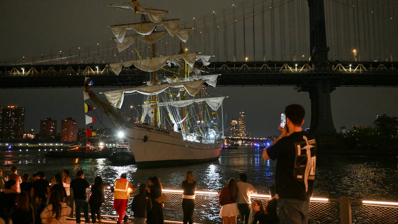 Personas observan cómo un buque escuela de la Armada de México es retirado tras estrellarse contra el Puente de Brooklyn en Nueva York, el 17 de mayo de 2025.