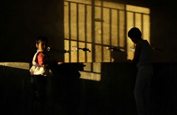 Niños refugiados lavan sus manos dentro de una cocina en un campo de refugiados temporal en el oeste de Líbano. (AP) 