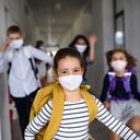 Group of cheerful children going home from school after covid-19 quarantine and lockdown, running.