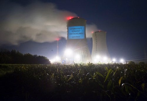 El mensaje "La energía nuclear perjudica a Alemania", firmado por Greenpeace, es proyectado sobre la torre de refrigeración de la planta nuclear de Grafenrheinfeld (Alemania).