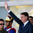 Brazilian President Jair Bolsonaro (C) waves next to his Defense Minister Braga Netto (R), and Navy Commander Almir Garnier (L), during a military vehicles parade in front of the Planalto Palace in Brasilia, on August 10, 2021. - Bolsonaro is accused of using the armed forces for a show of force to intimidate National Congress, where a bill is being debated to modify the electronic voting system. (Photo by EVARISTO SA / AFP)