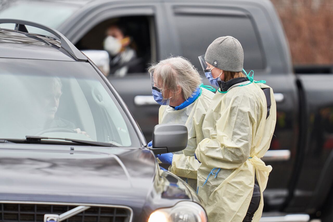 (FILES) In this file photo taken on March 17, 2020 health care workers speak with patients at a drive-thru Covid-19 assessment center in London, Ontario. - Canada surpassed 500,000 coronavirus cases on December 19, 2020, according to official figures, recording a 25 percent increase in just two weeks.