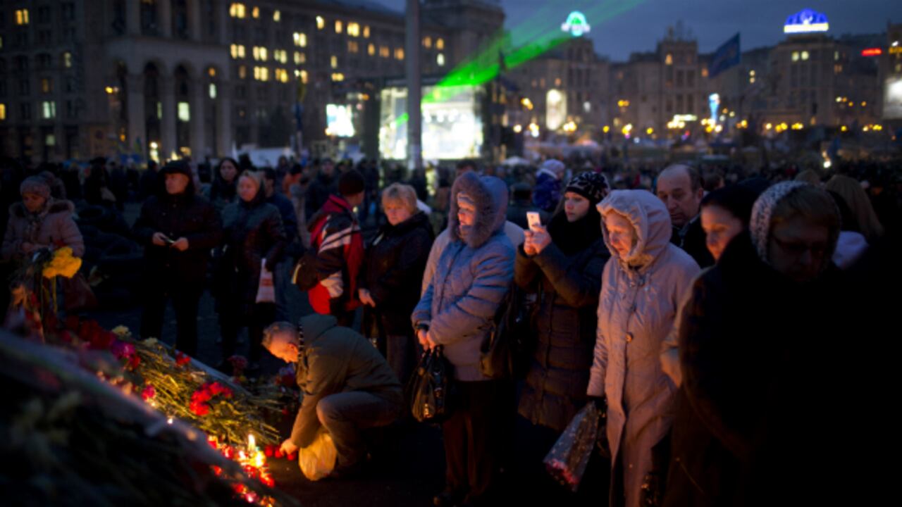 Ucranianos recuerdan a los manifestantes caídos en las protestas en un homenaje póstumo en la Plaza de la Independencia en Kiev.