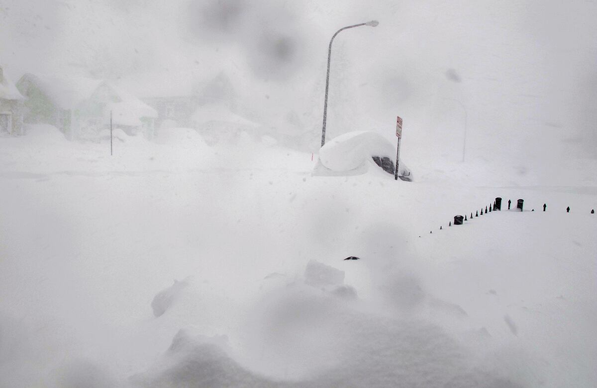 Una cerca de metro y medio y una camioneta están casi cubiertas por una nevada en Buffalo, Nueva York. Además de la nieve caída sobre el lugar, vientos de casi 50 kilómetros por hora obligaron a cerrar la autopista Interstate 90. (AP)