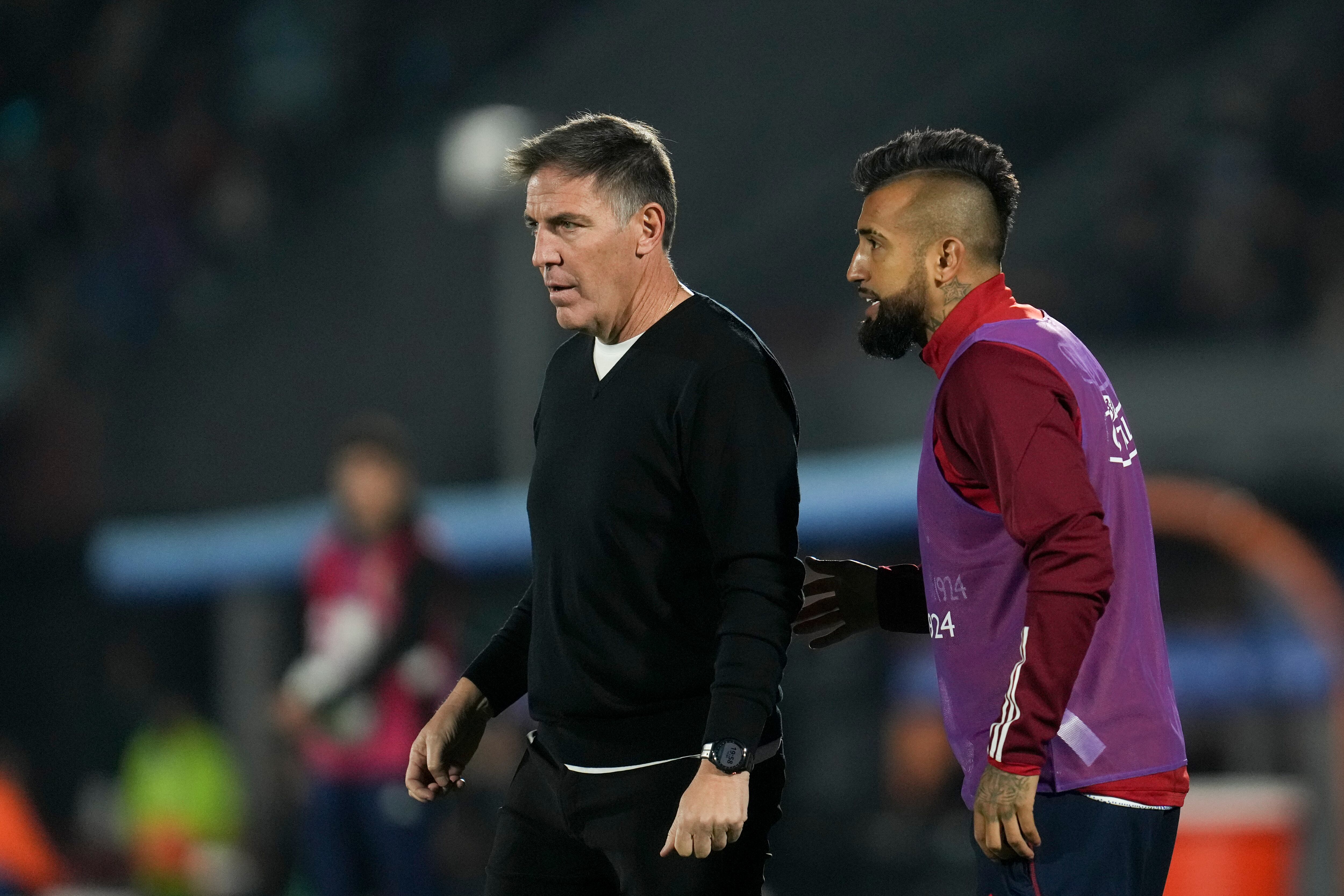 Chile's player Arturo Vidal, right, talks to his coach Eduardo Berizzo during a qualifying soccer match against Uruguay for the FIFA World Cup 2026 at Centenario stadium in Montevideo, Uruguay, Friday, Sept. 8, 2023.(AP Photo/Matilde Campodonico)