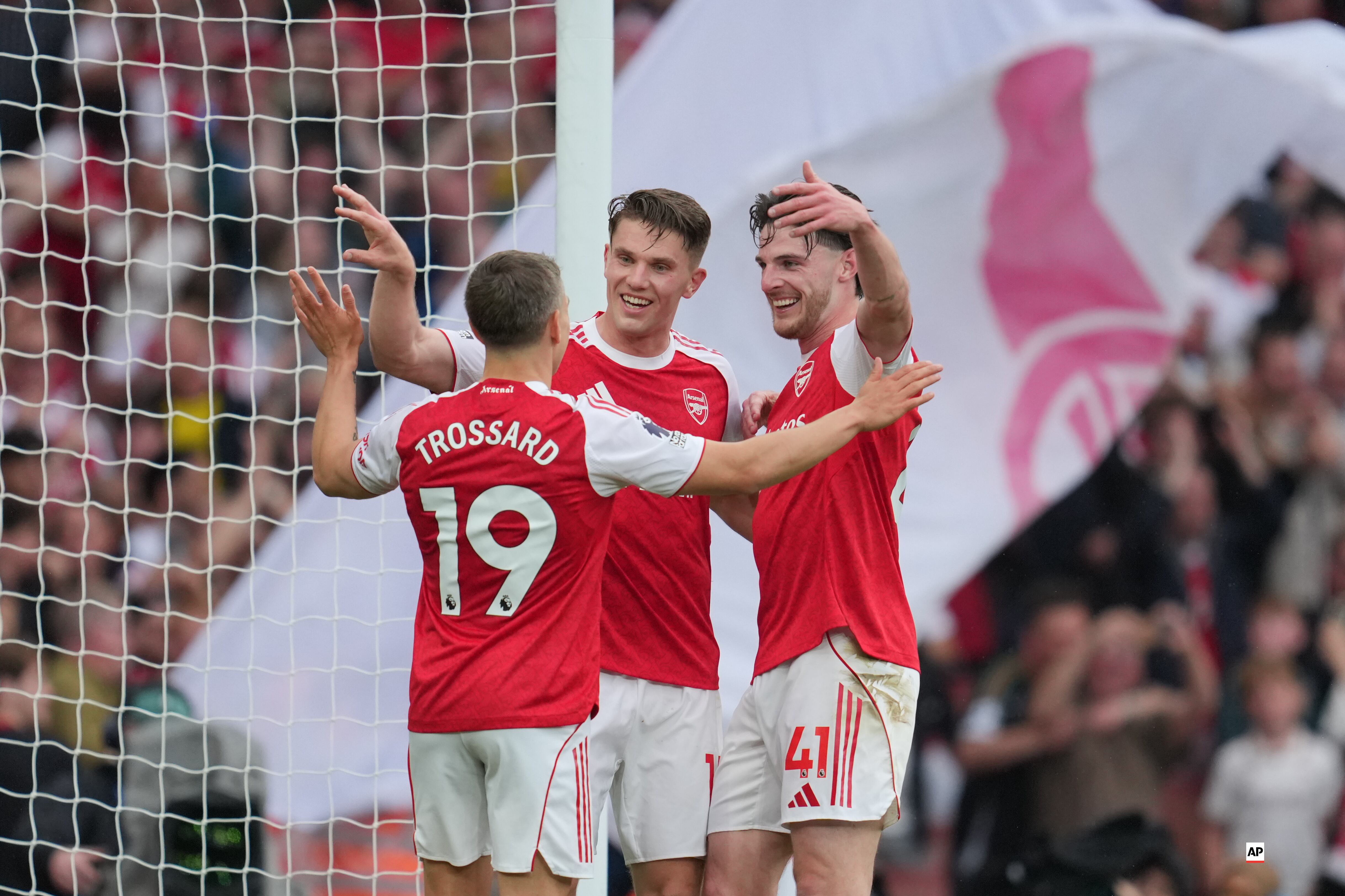 Arsenal's Viktor Gyoekeres, centre, celebrates with Arsenal's Declan Rice and Arsenal's Leandro Trossard, left, after scoring his side's third goal during the English Premier League soccer match between Arsenal and Fulham in London, England, Saturday, May 2, 2026. (AP Photo/Kin Cheung)