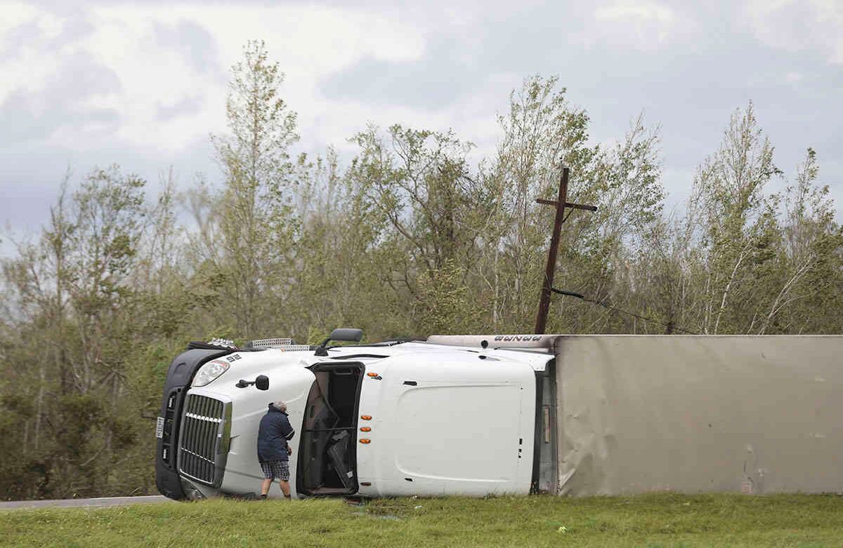 Un hombre mira dentro de un camión volcado de 18 ruedas al amanecer después de que el huracán Laura se moviera por el área el jueves 27 de agosto de 2020, cerca de Sulphur, Luisiana. Foto: Jon Shapley / Houston Chronicle vía AP