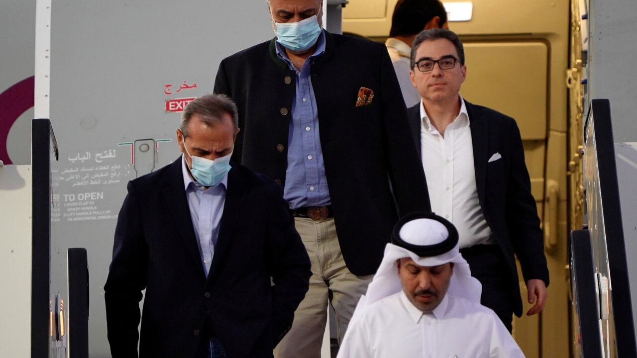 De izquierda a derecha, Emad Sharghi, Morad Tahbaz y Siamak Namazi, que estuvieron presos en Irán, desembarcan de un avión de Qatar Airways que los llevó de Teherán a Doha, Qatar, el 18 de septiembre de 2023. (AP Foto/Lujain Jo)