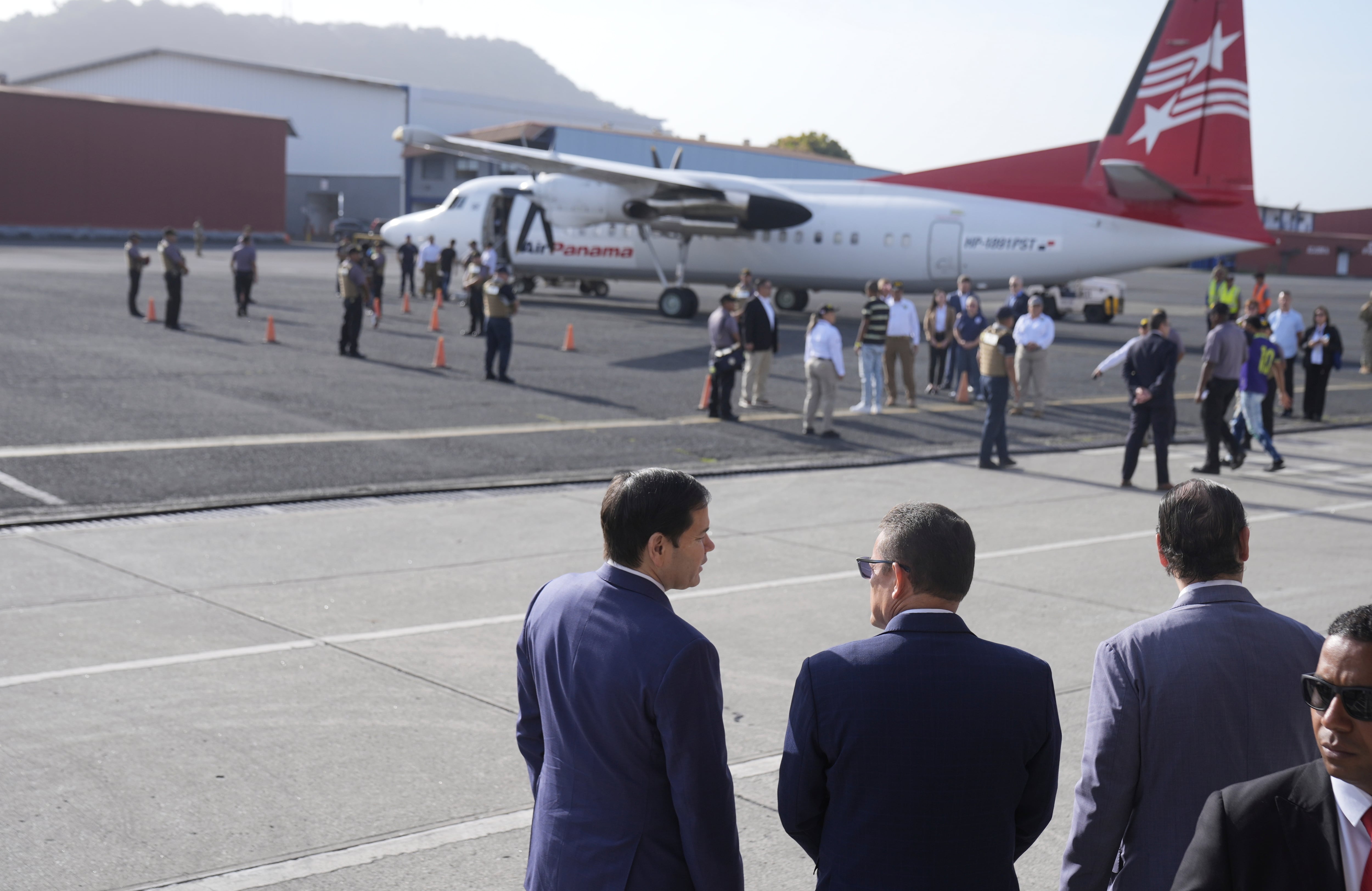 El secretario de Estado de Estados Unidos Marco Rubio, izquierda, dialoga con el ministro de Seguridad Pública panameño Frank Alexis Abrego, centro, y el ministro de Relaciones Exteriores de Panamá, Javier Martínez-Acha, cuando un grupo de personas aborda un vuelo de repatriación a Colombia, en el Aeropuerto Albrook de Ciudad de Panamá, el lunes 3 de febrero de 2025. (AP Foto/Mark Schiefelbein, Pool)